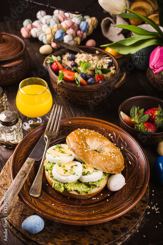 Healthy freshly baked bagel filled with boild eggs, avocado and chives. Breakfast food.