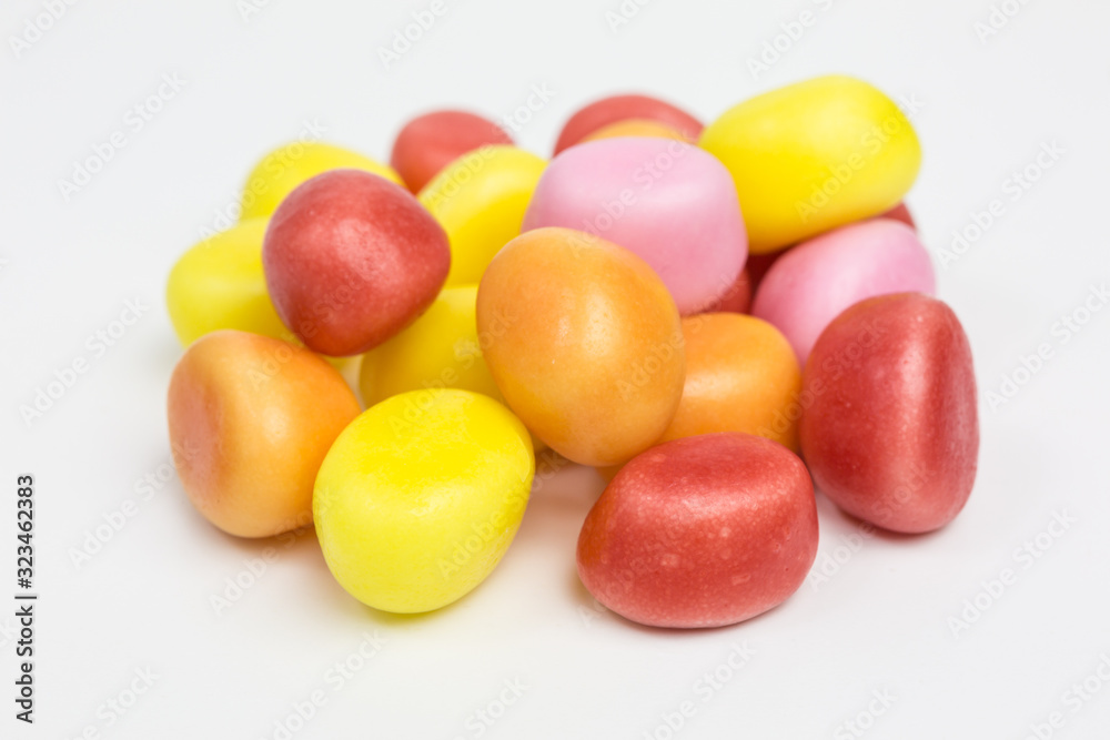 heap of sugar candy balls in yellow, pink, orange and red