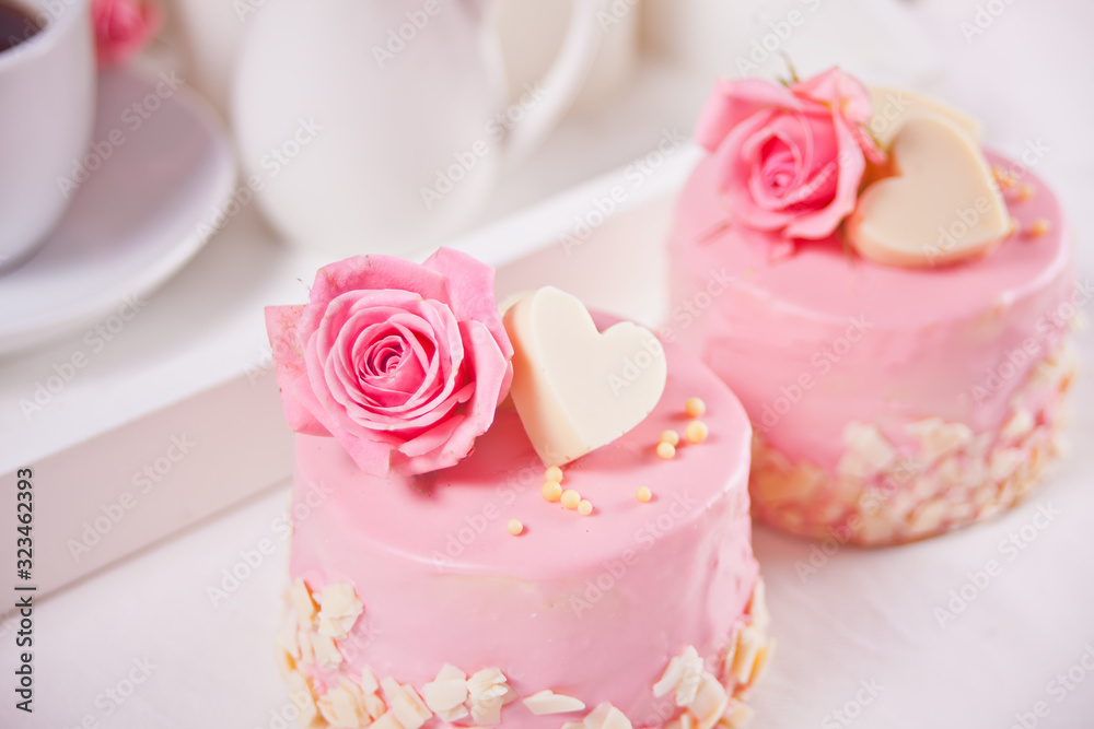 Two mini cakes with roses on a white table. Romantic dinner concept Two mini cakes with roses on a white table. Romantic dinner concept