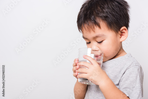 Closeup Asian face, Little children boy drinking water from glass