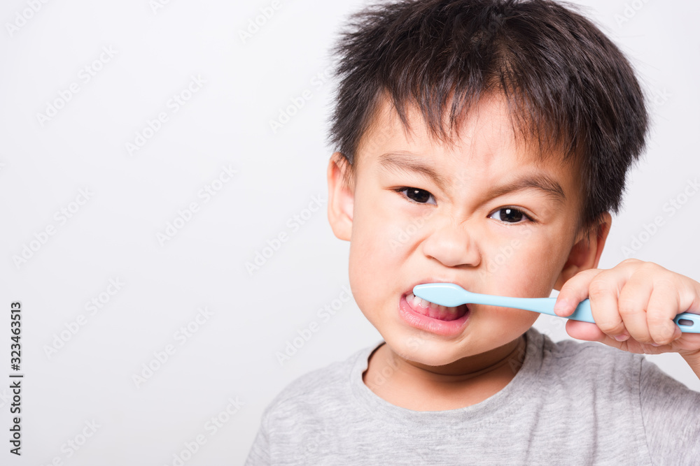 Closeup Asian face, Little children boy hand holds toothbrush he brushing teeth myself Closeup Asian face, Little children boy hand holds toothbrush he brushing teeth myself