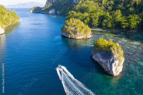 A small boat cruises through a narrow channel in Raja Ampat, Indonesia. This beautiful region is thought to be the world's epicenter of marine biodiversity.