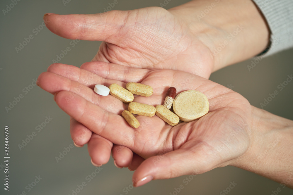 Girl holds handful of pills for treating diseases. Girl holds handful of pills for treating diseases.
