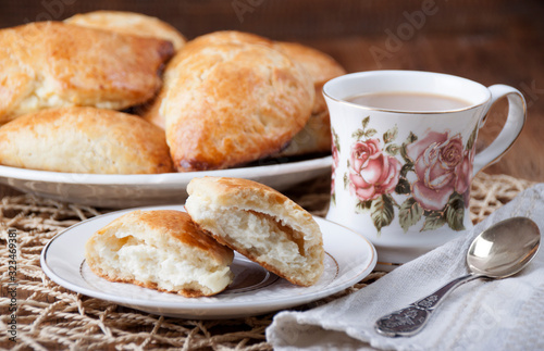 Cottage cheese pies in a plate and cup with coffee