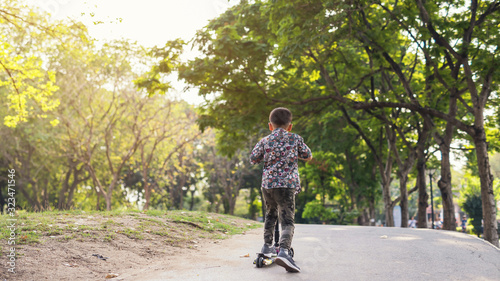 Wallpaper Mural Boy rides scooter uphill in summer park Torontodigital.ca