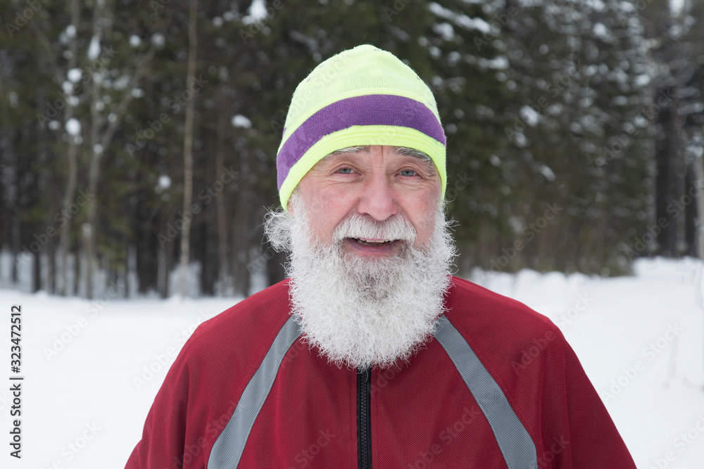 Fototapeta premium Portrait of an elderly man who runs in the woods. Active longevity.