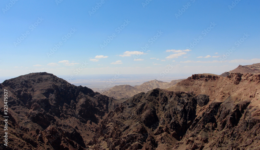 vast arid landscape in Jordan with black mountains in the foreground