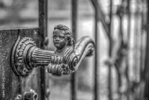 old metal gate handle with the face of a child on the top