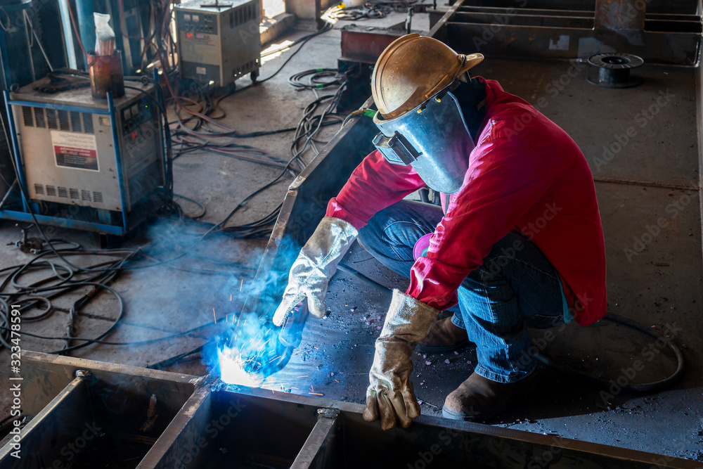 The welder is welding a steel structure work with process Flux Cored