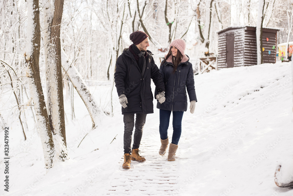 christmas happy couple in love walking in snowy winter cold forest