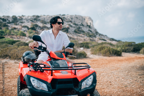 A man sits on a quad in the mountains