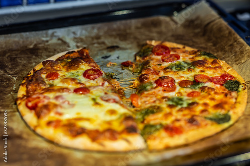 Newly baked pizza with tomato, mozzarella, onion, broccoli and cheese