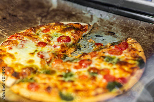 Newly baked pizza with tomato, mozzarella, onion, broccoli and cheese