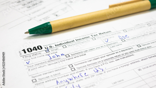 Filled 1040 Tax Form for male multiple-use names John Doe in USA. Wage and tax statement, federal income, medicare tax withheld, social security. Filing Individual income tax return in 2020 