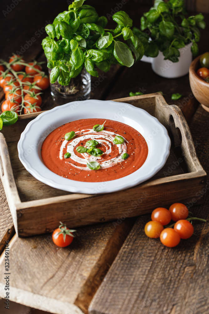 Bowl of tomato soup with a basil on wooden background Bowl of tomato soup with a basil on wooden background