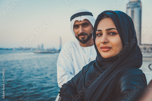 Canvas Print Happy couple in Dubai enjoying the sunset with the skyline view