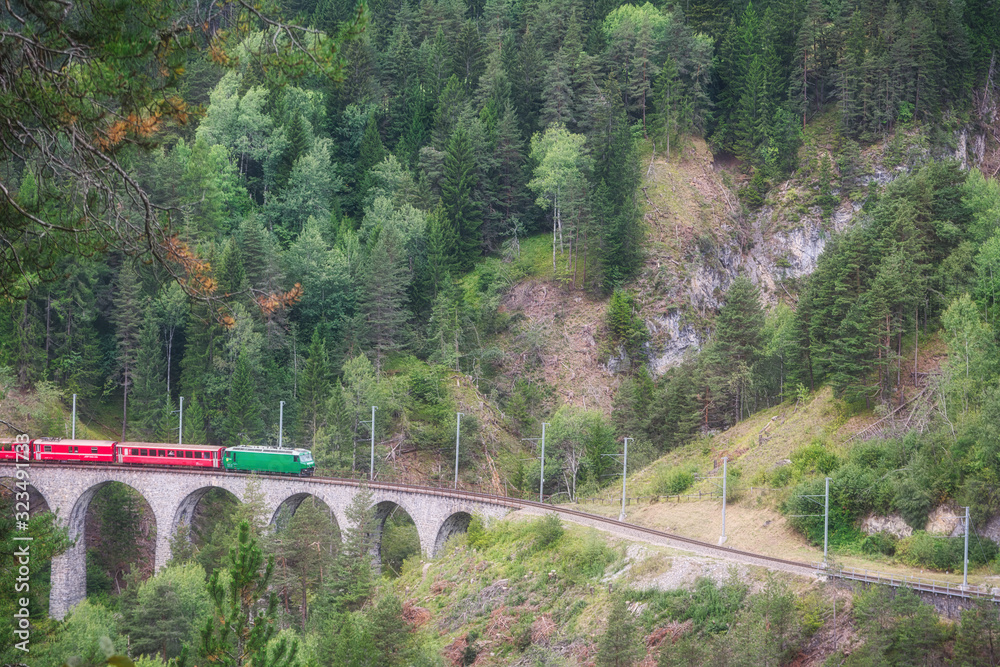 Red express train runs on famous Landwasser bridge in Filisur, the heart of Alpine mountains in Switzerland Red express train runs on famous Landwasser bridge in Filisur, the heart of Alpine mountains in Switzerland
