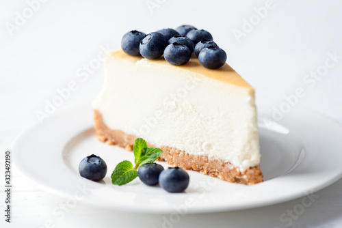 Classical New York Cheesecake with blueberries on white background. Closeup view