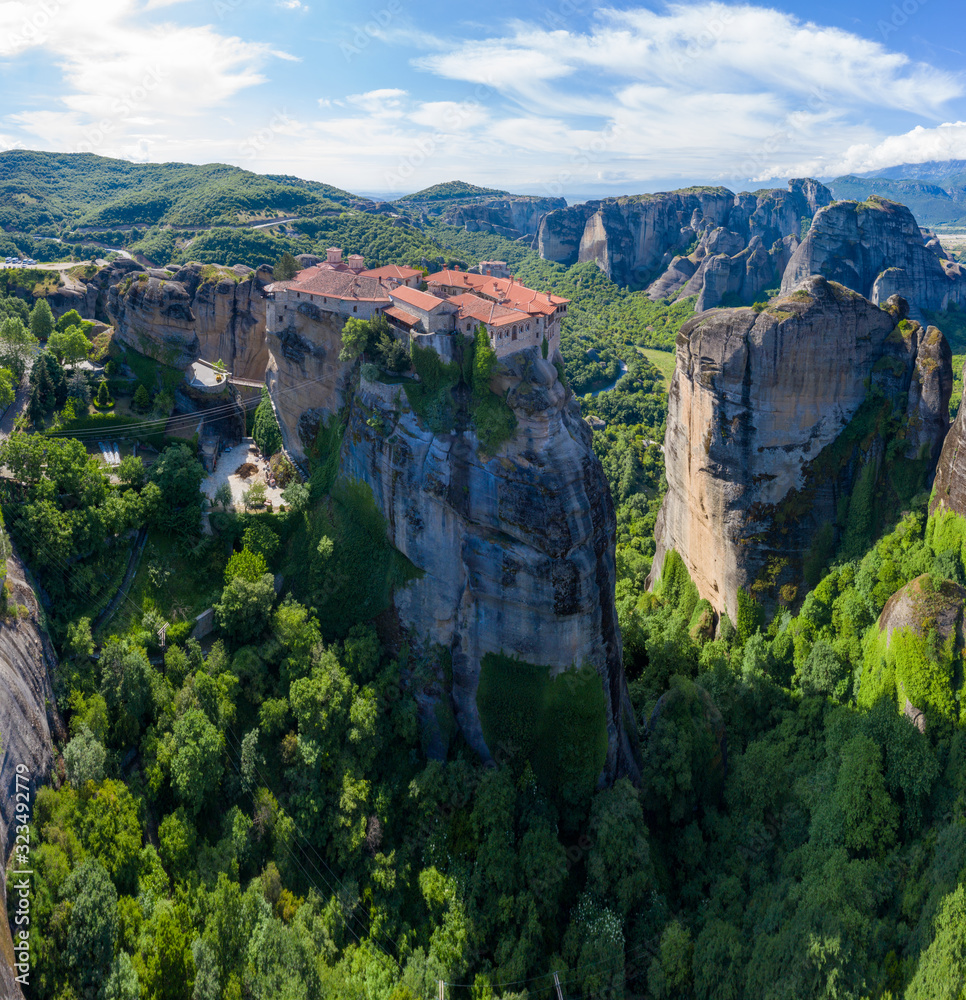 Aerial panorama view of a slide from a drone on a panorama of a mountain range. Kalampaka city, Greece. View of the cliffs of Meteora and the monasteries of Meteora. Aerial panorama view of a slide from a drone on a panorama of a mountain range. Kalampaka city, Greece. View of the cliffs of Meteora and the monasteries of Meteora.