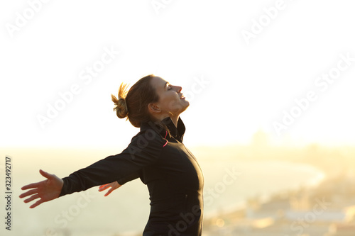 Runner relaxing breathing fresh air outstretching arms photo