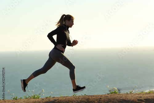 Runner silhouette running on the beach