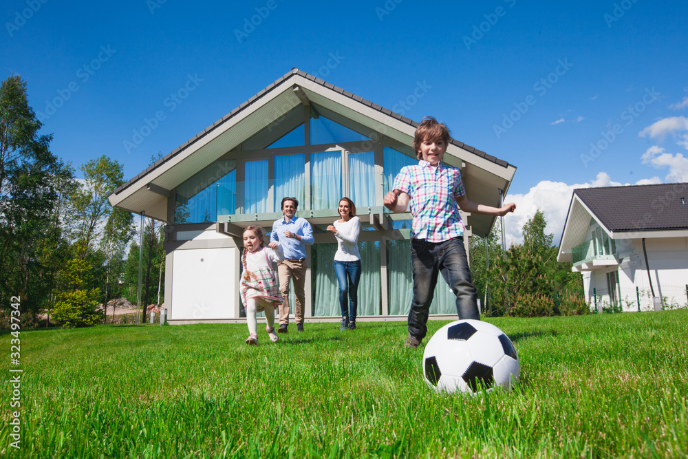 Happy multi generation family playing football together in the park ...