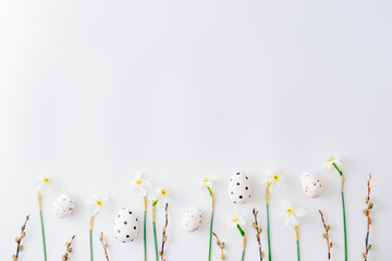 Flat lay easter composition with a white daffodils and eggs on a white background