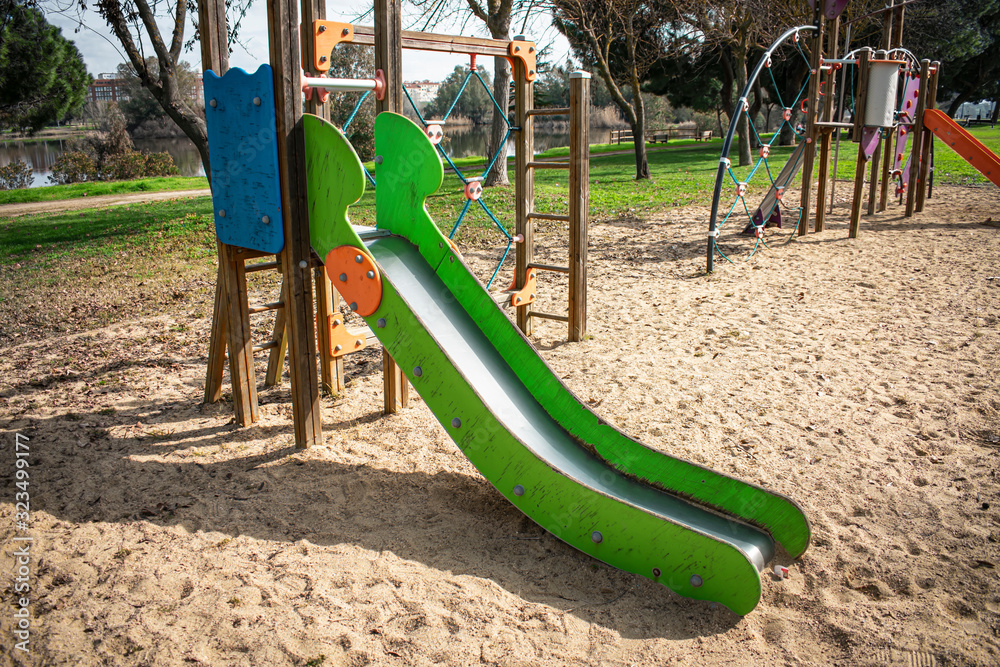 Entrance to a children's slide located in a game package with grass and trees Entrance to a children's slide located in a game package with grass and trees