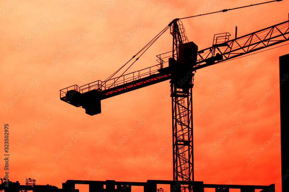 Crane and building construction site at sunset