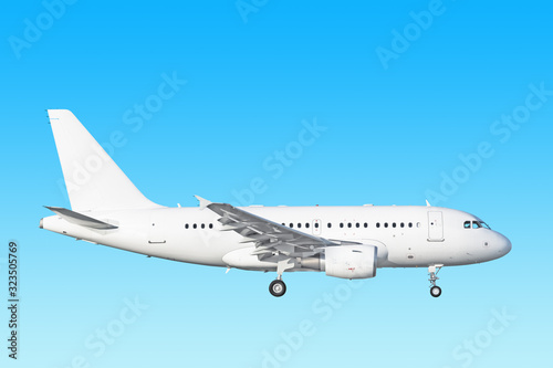 white airplane side view isolated on blue sky background. Passenger jet plane with gear up. Commercial aircraft paint scheme. Luxury business jet flying in air. Aviation design reference photo