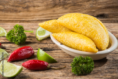 Empanadas and hot pepper on wooden background, traditional Colombian food