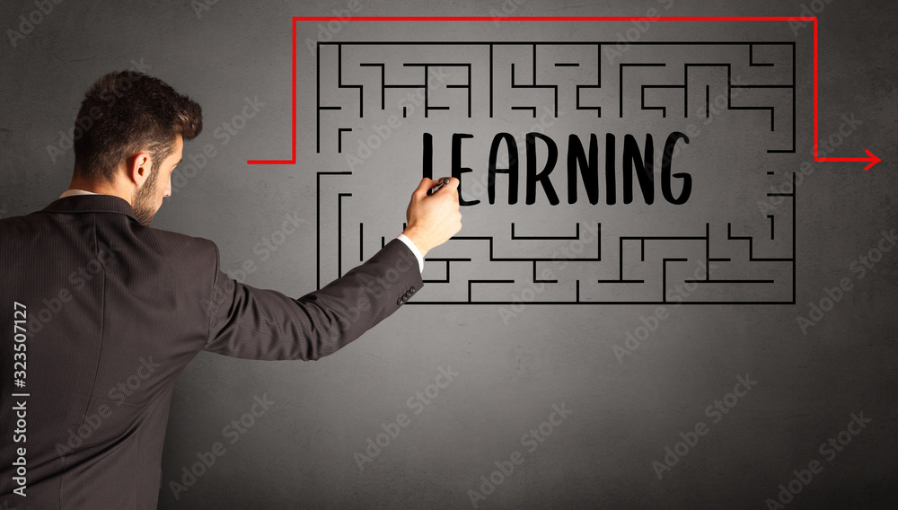 businessman drawing maze with LEARNING inscription, business education concept businessman drawing maze with LEARNING inscription, business education concept
