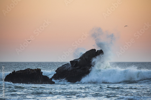 Fototapeta Naklejka Na Ścianę i Meble -  Wild Waves hitting a Rock in a beautiful sunset