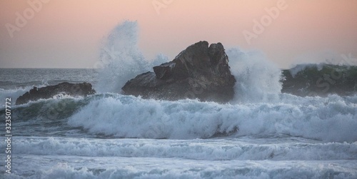 Foto Wild Waves hitting a Rock in a beautiful sunset