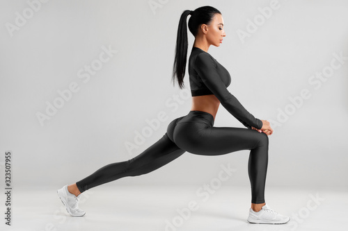 Fitness woman doing lunges exercises for leg muscle workout training. Active girl doing front forward one leg step lunge exercise for butt, isolated