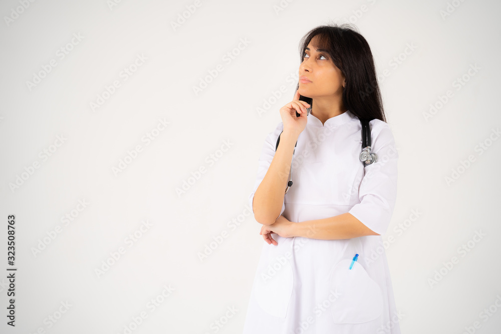 A young girl doctor or student with a phonendoscope stands on a white background A young girl doctor or student with a phonendoscope stands on a white background