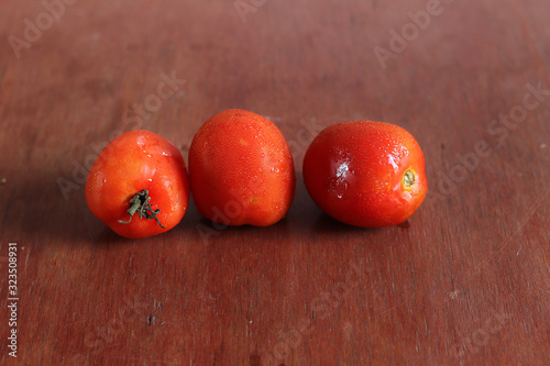 Fresh tomato against a wooden background to show concept of gastronomy, healthy diet and clean eating