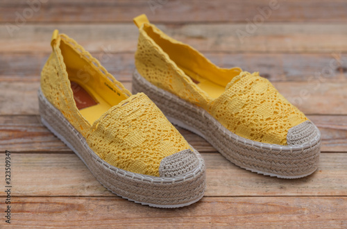 Espadrilles with rubber sole on wood background, close-up