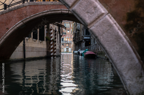 canal leads to Canale Grande with boats moored in Venice