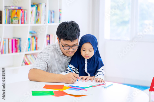 Man teaching his adorable daughter how to draw