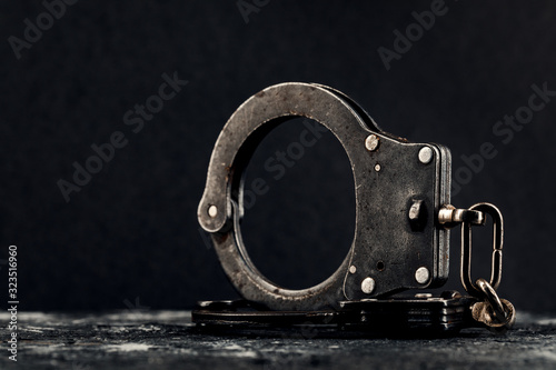 Handcuffs on a dark background. The concept of crime and police. photo