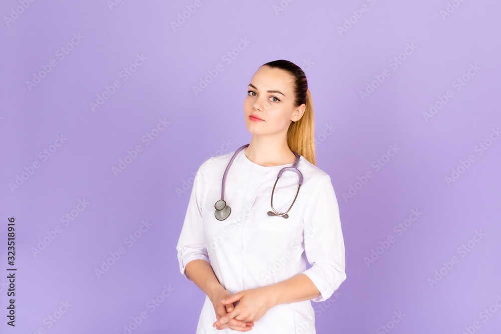 Medical concept of beautiful female doctor in white coat with phonendoscope. Medical student general practitioner. Woman hospital worker looking at camera and smiling, studio, purple background. Medical concept of beautiful female doctor in white coat with phonendoscope. Medical student general practitioner. Woman hospital worker looking at camera and smiling, studio, purple background.
