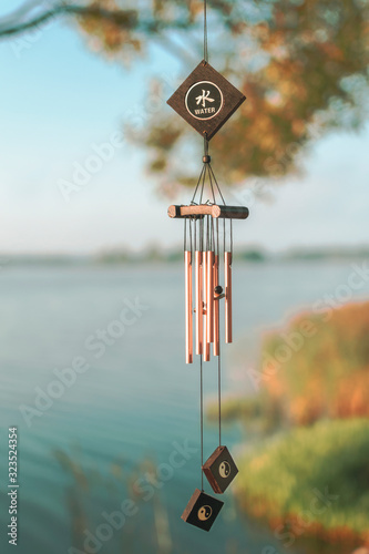 a wind chime meaning water element. summer lake on blurry background
