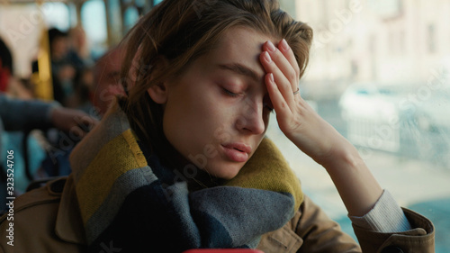 Portrait young attractive woman look on window on the tram on a cold autumn day at the start of the flu season disease fever flu grippe health illness infection influenza migraine sickness slow motion