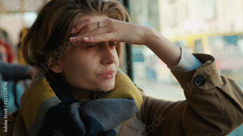Sick young woman coughs sneezes on the tram cold autumn day flu season disease fever grippe health illness infection influenza migraine sickness slow motion