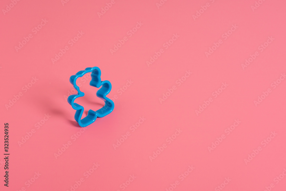 Blue plastic cookie cutter for making cookies in the shape of a teddy bear on a pink background. Culinary concept. Flat lay with copyspace. Blue plastic cookie cutter for making cookies in the shape of a teddy bear on a pink background. Culinary concept. Flat lay with copyspace.