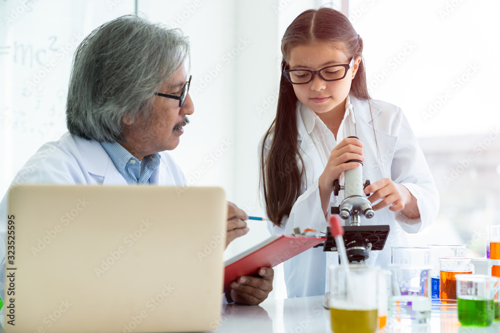 Science teacher teach useing microscope with Asian students on table in laboratory room, concept for study in laboratory room.