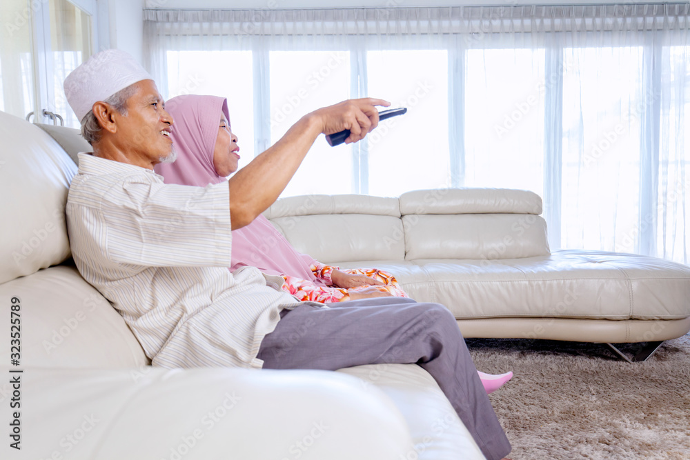 Side view of elderly couple watching television Side view of elderly couple watching television
