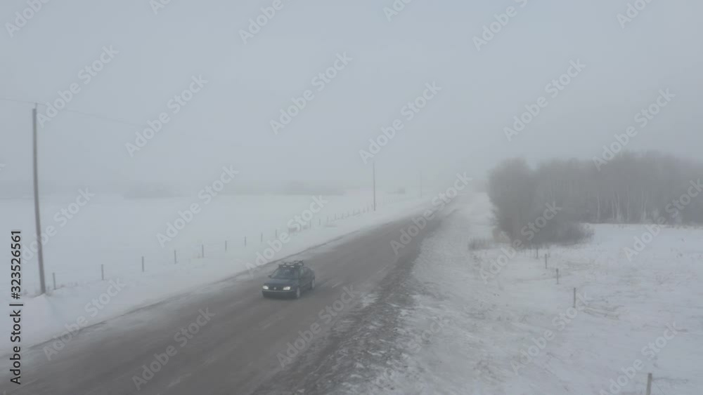 Car zooming by in thick fog. Drone shot. Car zooming by in thick fog. Drone shot.