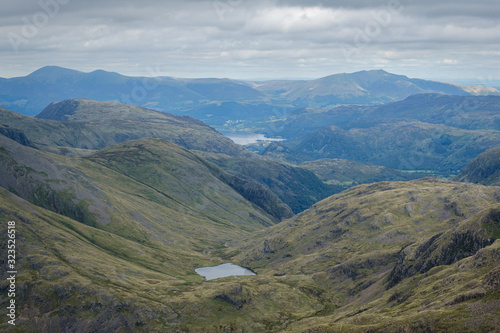 Obraz na płótnie Green rolling hills from the summit of Scafell Pike towards Buttermere lake on an overcast and cloudy day w salonie